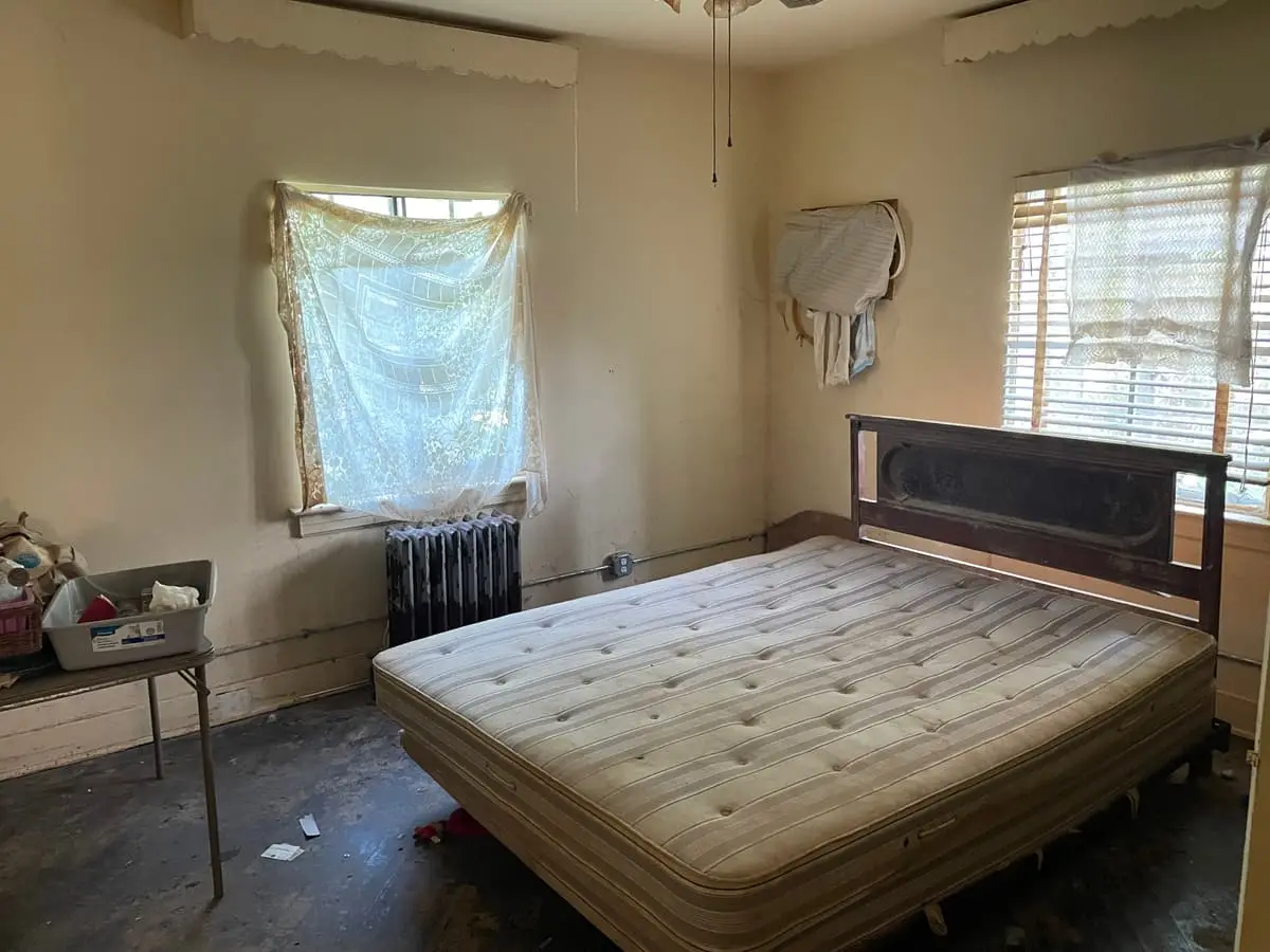 Selling an inherited house in Hempstead: bedroom with a bare mattress, old dresser and radiator