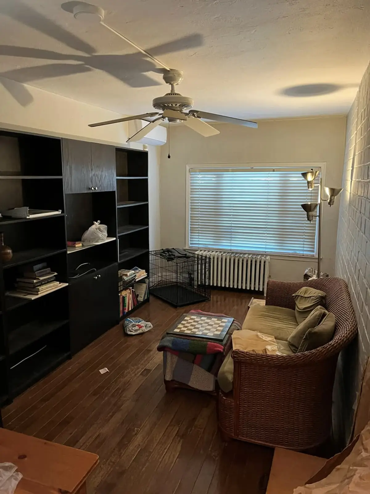 Selling a house during a divorce in Hempstead: occupied living room with built-in shelves and a ceiling fan