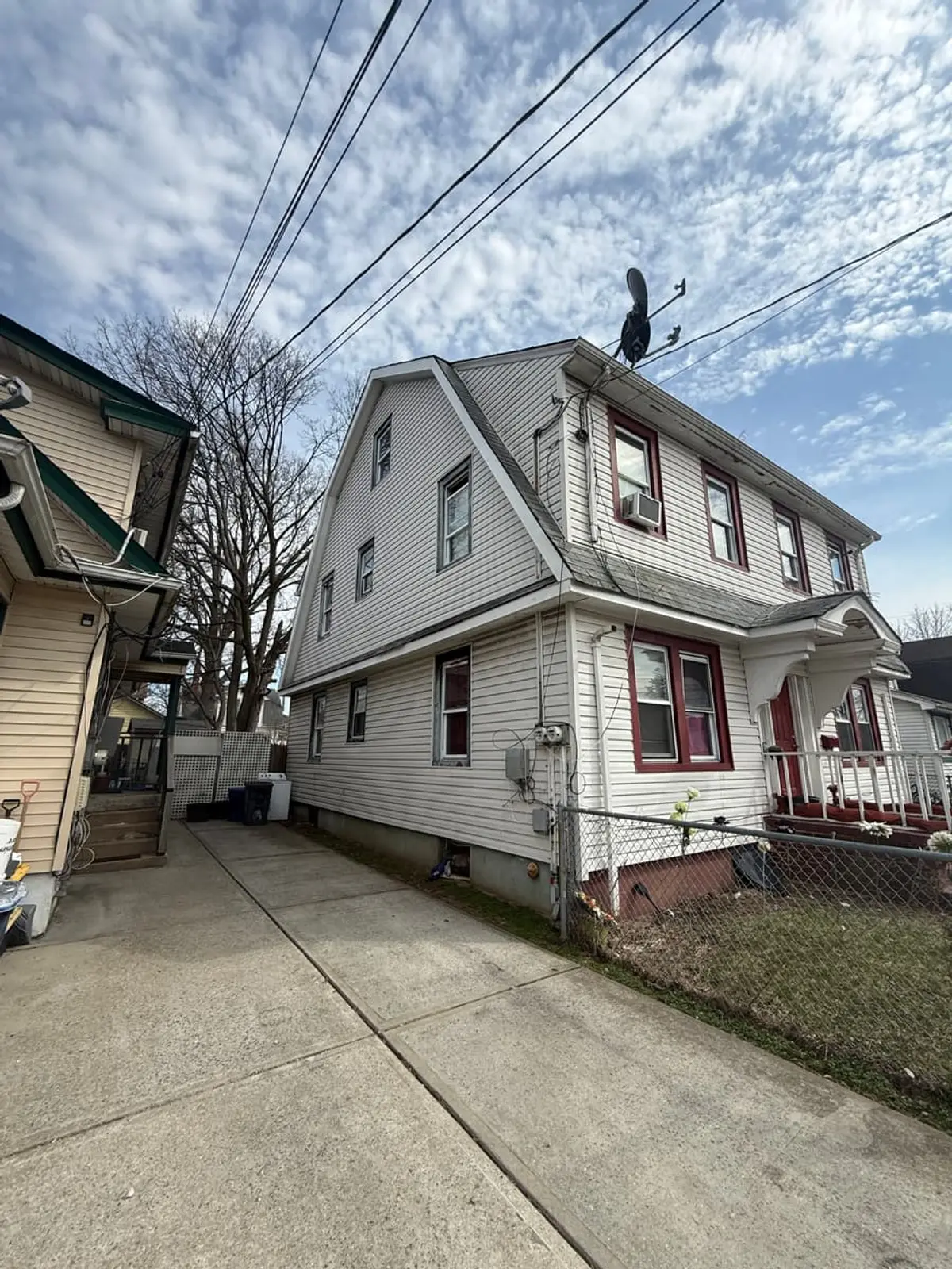 Selling a house after a life change in Hempstead: two-family house with white siding beside a long driveway
